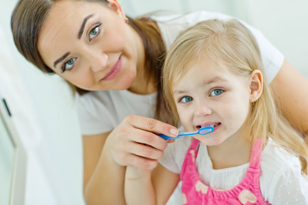 Mom and Daughter brushing their teeth - Pediatric Dentist in Madison, MS
